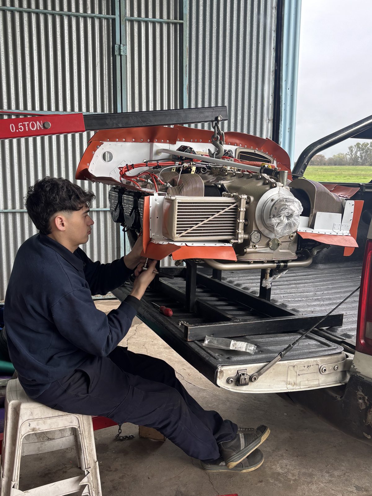Ezequiel trabajando sobre motor instalado en aeronave